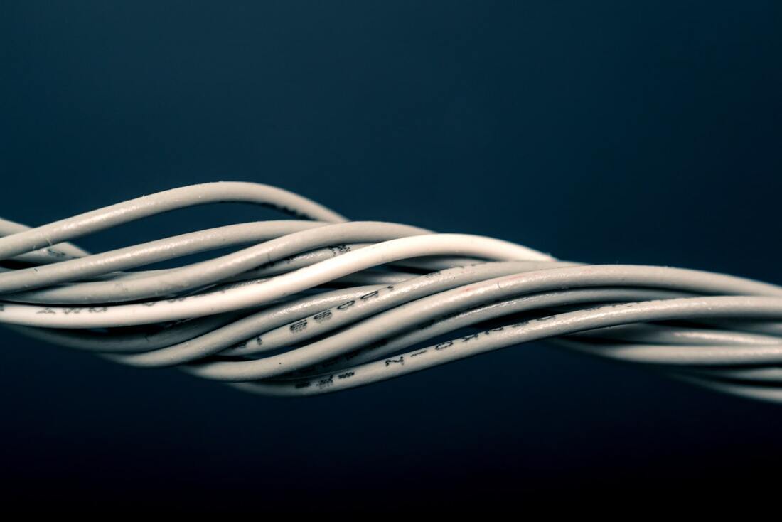 Twisted wiring encased in white plastic against a blue background